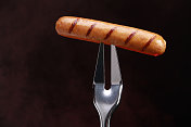 叉子上的烤热狗或香肠
