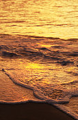 日落时在海滩冲浪
