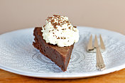 白色盘子上的一块无面粉巧克力蛋糕