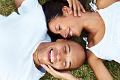 一对年轻夫妇一起躺在草地上玩