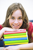 十几岁的女孩在一堆五颜六色的课本上放松(二)