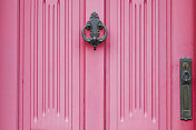 粉红色的门与一个华丽的门环和钥匙锁