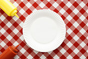 野餐桌，白色盘子，番茄酱和芥末