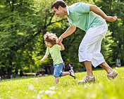 父亲和儿子在公园里跑步。