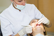 女牙医在牙医椅上与女病人一起工作