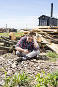 压力山大，悲伤的十几岁男孩坐在农场柴堆旁