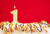 用燃烧的1号蜡烛装饰生日蛋糕。红色的背景。