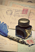 羽毛笔，墨水瓶和旧明信片。