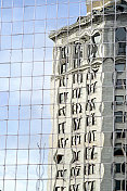 旧建筑在新摩天大楼的扭曲反射