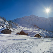 高山小屋覆盖着积雪，冬天，阳光明媚，景色美妙