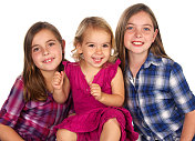 三个美丽的年轻姐妹微笑在白色的背景