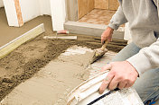 瓷砖工人在浴室地板上铺薄灰泥
