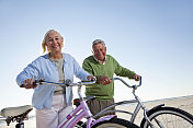 在海滩上骑自行车的老年夫妇
