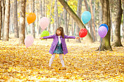 小女孩在大自然中与气球摆姿势