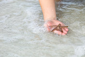 孩子手握海星在海洋冲浪