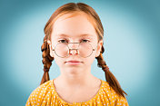 小女孩看着她的书呆子眼镜上面