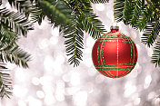 挂在松树上的圣诞装饰物，背景有灯光