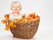 小女孩在秋天的篮子里