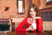 美丽的女人在咖啡馆喝茶。