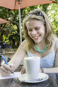 年轻女士在咖啡店做笔记