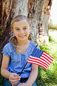 微笑的女孩挥舞着美国国旗