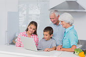 祖父母和孙辈一起使用笔记本电脑