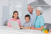 祖父母和孙辈一起使用笔记本电脑