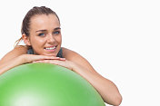 运动美女用健身球支撑自己