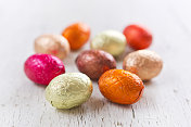 在纯朴的白色背景上点缀着小的巧克力复活节彩蛋