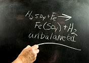 科学老师在黑板上展示一个方程式。