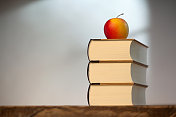木桌上放着书和苹果
