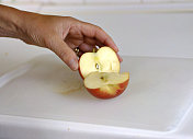鲜苹果，切成两半，用手拿着