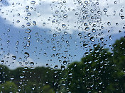 雨滴在窗口与失焦景观背景