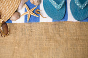 暑假的场景。贝壳，太阳镜，戴着沙滩毛巾的帽子。