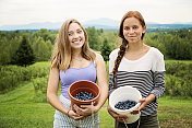 可爱的青少年展示着夏天刚摘下来的蓝莓。