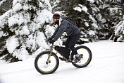 在雪地里骑着胖自行车的大胡子男人