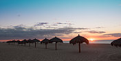 热带棕榈海滩伞在日落…特写镜头
