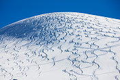 雪覆盖了小山，留下了滑雪的痕迹