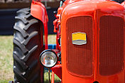 在一辆修复过的1950年代的红色旧拖拉机前面