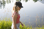 年轻女子沿着山湖边散步