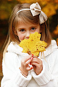 小女孩拿着一片叶子