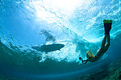 女孩在水下拍摄冲浪者的剪影