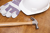 木桌上的施工工具。安全帽，手套，锤子。
