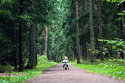 男孩骑着平衡自行车在森林里骑车
