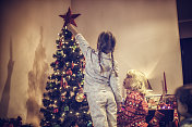 可爱的女孩装饰圣诞树