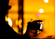 一个男人在酒吧喝啤酒的剪影