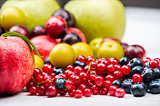 红醋栗和蓝莓与其他水果在木板的背景