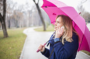 年轻女子与手机在雨天