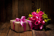 带有粉色蝴蝶结和玫瑰花束的礼盒