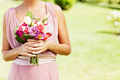 户外婚礼上，伴娘手捧花束